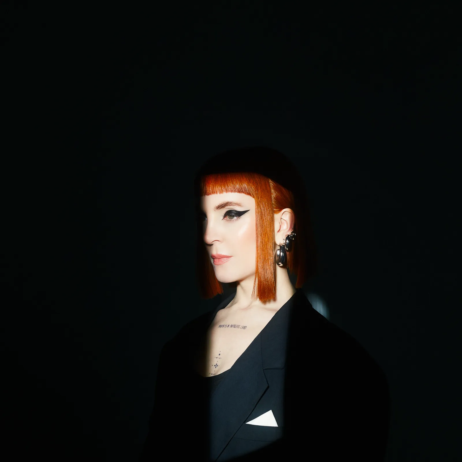 BG-psicoterapia Valentina Moyano de perfil sobre fondo oscuro
